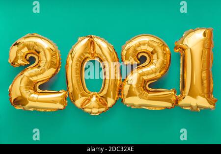 2021 Luftballon Gold Text auf grünem Hintergrund. Frohe Silvester Einladung mit Weihnachten Goldfolie Ballons 2021. Stockfoto