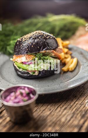 Schwarzer Burger gefüllte Lachs Avocado und Gurkensalat mit Pommes frites Stockfoto