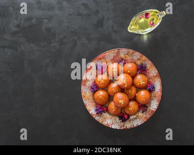 Indische traditionelle süße Gulab Jamun auf schwarzem Tisch, Draufsicht, Kopierraum. Stockfoto