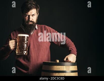 Mann mit Bier. Bier in Großbritannien. Biersorten und -Stile. Deutschland Bayern. Bärtiger Mann trinkt Lagerbier. Stockfoto