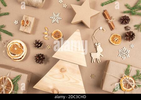 Weihnachtskomposition. Hausgemachter Weihnachtsbaum aus Holz, Geschenke, Urlaubsdekor auf hellbeigem Hintergrund, Nahaufnahme. Konzept weihnachten Null Abfall, umweltfreundlich. Stockfoto