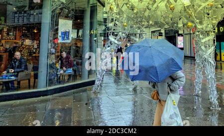 Glasgow, Schottland, Großbritannien. 18. November 2020: UK Wetter: Rain Fridays Tier 4 trug zum Elend der Einheimischen bei, da Regenschirme und Gesichtsmasken die Kennzeichen des Elends und eine neue Bedeutung für den schwarzen Freitag waren. Quelle: Gerard Ferry/Alamy Live News Stockfoto