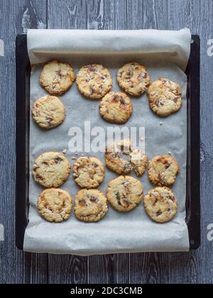 Shortbread mit Datteln auf einem Backblech wird auf einer dunklen Holzfläche angelegt. Draufsicht. Stockfoto