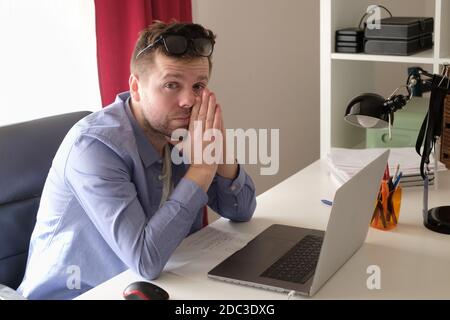 Müde junge Geschäftsmann arbeiten auf Laptop-Computer zu Hause Stockfoto