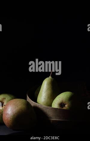 Birnen isoliert auf schwarzem Hintergrund, dunkle launische Fruchtkomposition im barocken künstlerischen rembrandt-Lichtstil, Fine Art Design, veganes Essen und Gesundheit Stockfoto