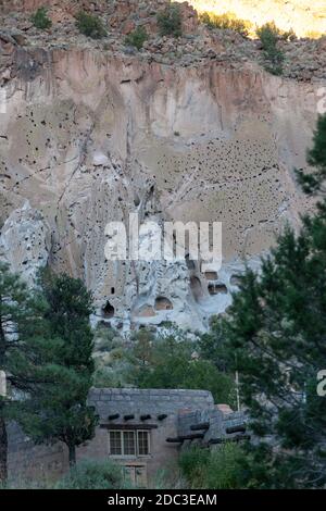 Moderne Gebäude im Pueblo-Stil dienen als ein Besucherzentrum und Souvenirladen in Bandelier National Monument mit Hohe erodierte Sandsteinwände Stockfoto