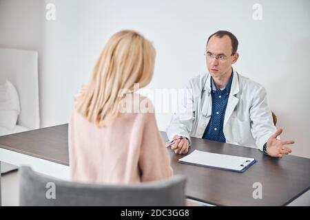 Arzt mit einem Stift in der Hand und Beratung des Patienten Stockfoto