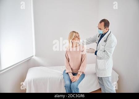 Erfahrener männlicher Arzt, der die Wirbelsäulenuntersuchung durchführt Stockfoto