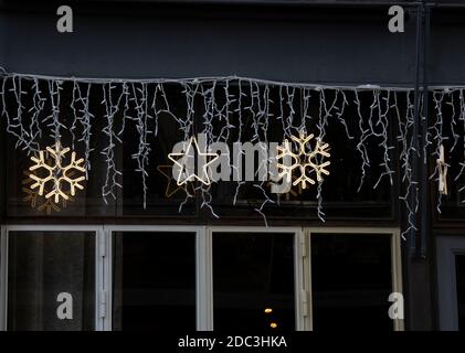 Zur Weihnachtszeit hingen Schneeflocken-Ornamente auf dem Gebäude. Stockfoto