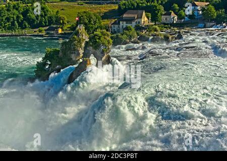 Felseninsel im rauschenden Wasser am Rheinfall zur Zeit der Schneeschmelze in den Alpen, Laufen-Uhwiesen bei Schaffhausen, Schweiz Stockfoto
