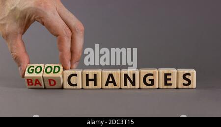 Männliche Hand dreht Würfel und ändert den Ausdruck "schlechte Änderungen" in "gute Änderungen". Schöner grauer Hintergrund. Speicherplatz kopieren. Stockfoto