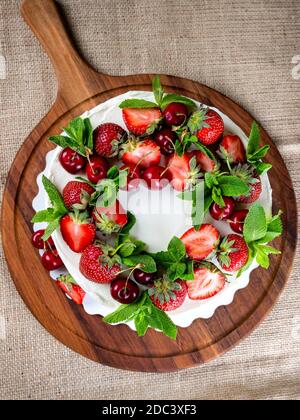 Schöne Kekskuchen mit weißer Sahne verziert mit Erdbeeren und Blaubeeren Stockfoto