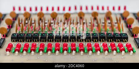 Leistungswiderstände, Optokoppler und Keramikkondensatoren in Reihen. Alte Leiterplatte. Altes elektronisches Gerät für Datenverbindungen galvanische Trennung. E-Waste. Stockfoto