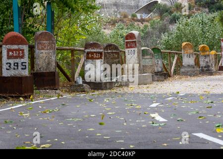 Alte Meilensteine, die auf der Straße Bailen-Motril (N-323) bei der Durchfahrt durch La Cerradura de Pegalajar (Jaen-Spanien) aufgedeckt wurden Stockfoto