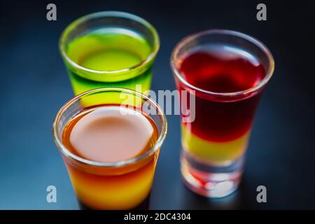 Drei alkoholische mexikanische Schüsse für Party in der Bar.Bunte Alkohol serviert In drei Shot-Gläsern auf Barständer, in Nahaufnahme aufgenommen Stockfoto