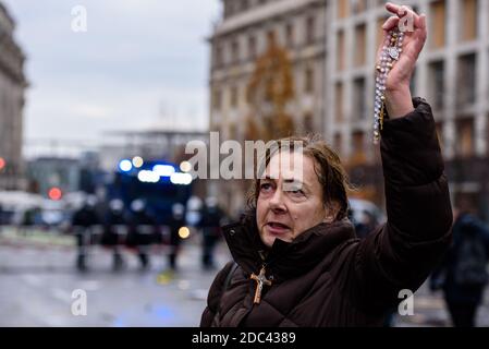 Berlin, Deutschland. November 2020. Deutschland, Berlin, 18. November 2020: Eine Frau betet, während sie einen Rosenkranz hält, nachdem heterogene Gruppen um Corona-Leugner, Verschwörungstheoretiker und Rechtsextremisten dazu aufgerufen hatten, den Zugang zu deutschen Regierungsgebäuden zu blockieren. Sowohl Bundestag als auch Bundesrat stimmen am 18. November 2020 über geplante neue Regelungen des Infektionsschutzgesetzes ab. (Foto: Jan Scheunert/Sipa USA) Quelle: SIPA USA/Alamy Live News Stockfoto