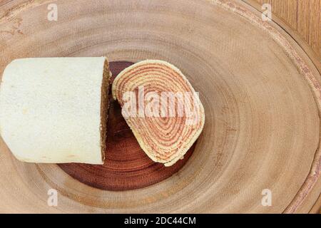 Ein Stück bolo de rolo (Kuchen Rollen) auf einem Holzbrett. Stockfoto