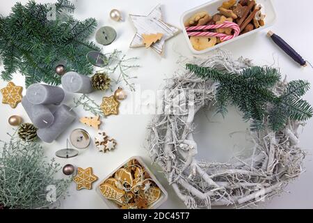 Selbstgemachter Adventskranz aus Holz schmückt mit Tannenzweigen, Lebkuchengebäck, weihnachtsschmuck und Kerzen, Hochwinkelansicht von oben Stockfoto