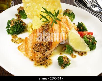 Gegrilltes Lachssteak mit Broccoli, Kartoffelpüree Käsekracker auf Holzhintergrund Stockfoto