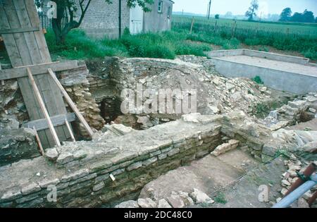 North Leigh Villa - römische Ruinen - archäologische Ausgrabungen, Juli 1977. Die Überreste der römischen Villa von North Leigh in einer ruhigen Landschaft am Ufer des Flusses Evenlode in Oxfordshire. Diese 'Hofvilla' gilt als eine der größeren Villen des römischen Britanniens. Es war am umfangreichsten im frühen 4. Jahrhundert, einschließlich: 4 Bäder, 16 Mosaikböden und 11 Zimmer mit Fußbodenheizung. Heute ist die rechteckige Anordnung der Villa mit fast vollständigen Mosaikfliesen aus dem 3. Jahrhundert sichtbar. English Heritage Site. Von Objektträgern gescannt. Stockfoto