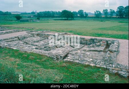 North Leigh Villa - römische Ruinen - archäologische Ausgrabungen, Juli 1977. Die Überreste der römischen Villa von North Leigh in einer ruhigen Landschaft am Ufer des Flusses Evenlode in Oxfordshire. Diese 'Hofvilla' gilt als eine der größeren Villen des römischen Britanniens. Es war am umfangreichsten im frühen 4. Jahrhundert, einschließlich: 4 Bäder, 16 Mosaikböden und 11 Zimmer mit Fußbodenheizung. Heute ist die rechteckige Anordnung der Villa mit fast vollständigen Mosaikfliesen aus dem 3. Jahrhundert sichtbar. English Heritage Site. Von Objektträgern gescannt. Stockfoto