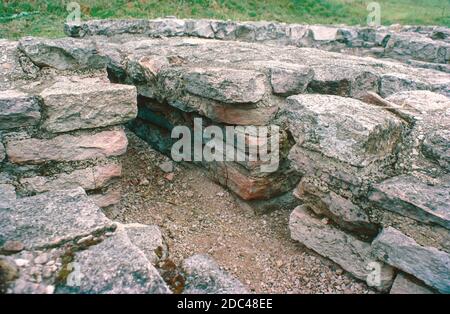 North Leigh Villa - römische Ruinen - archäologische Ausgrabungen, Juli 1977. Die Überreste der römischen Villa von North Leigh in einer ruhigen Landschaft am Ufer des Flusses Evenlode in Oxfordshire. Diese 'Hofvilla' gilt als eine der größeren Villen des römischen Britanniens. Es war am umfangreichsten im frühen 4. Jahrhundert, einschließlich: 4 Bäder, 16 Mosaikböden und 11 Zimmer mit Fußbodenheizung. Heute ist die rechteckige Anordnung der Villa mit fast vollständigen Mosaikfliesen aus dem 3. Jahrhundert sichtbar. English Heritage Site. Von Objektträgern gescannt. Stockfoto