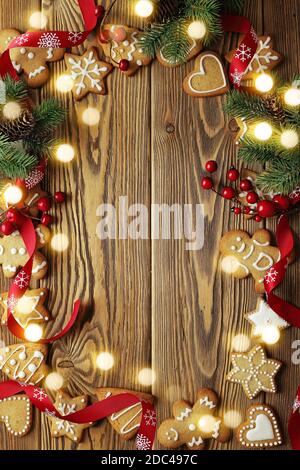 weihnachts-Grußkarte mit Lebkuchen und weihnachtsschmuck. Holzhintergrund mit Kopierraum Stockfoto