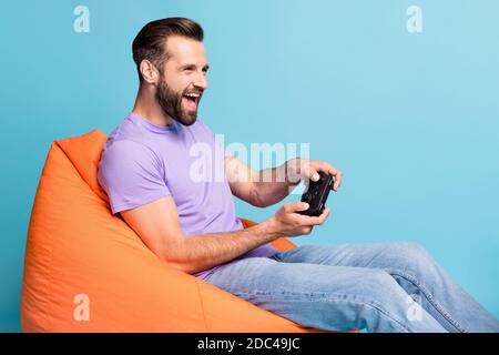 Foto Porträt von aufgeregt jungen Studenten spielen Videospiele halten Controller auf hellblauem Hintergrund isoliert Stockfoto