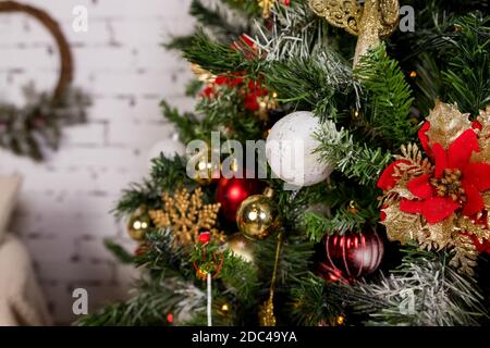 Schöne weihnachtsblume, rote und weiße Kugeln hängen auf weihnachtsbaum.Weihnachtsdekorationen. Neujahr Dekor für Wohnzimmer.Baum Zweig dekoriert Stockfoto