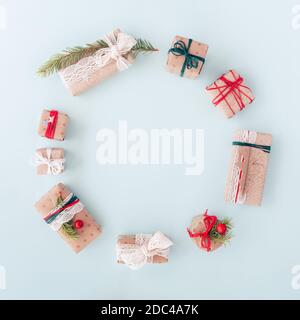 Weihnachtskreis Geschenk Komposition. Kranz aus Tannenbaum, Preiselbeeren und weißen Konfetti-Sternen auf blauem Hintergrund. Einfaches Design. Flach liegend Stockfoto