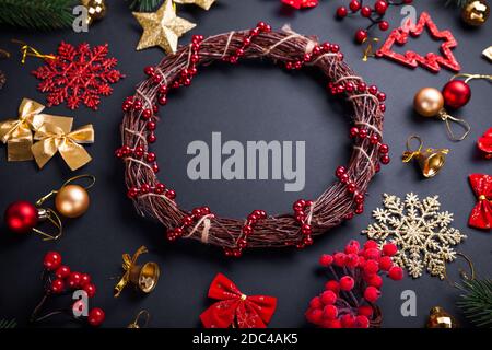 Weihnachtskranz mit Dekoration. Weihnachten und Neujahr schwarzer Hintergrund mit Ornamenten. Erstellen von handgefertigten Kranz. Platz. Stockfoto