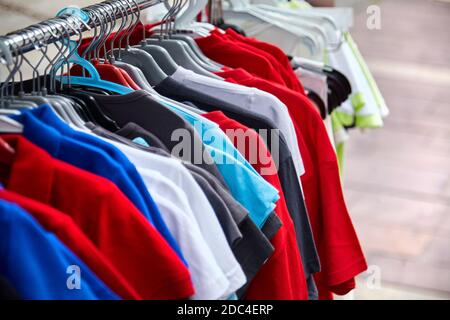 Buntes Polo-T-Shirt für den Mann auf Kleiderbügel in einem Einzelhandelsgeschäft Stockfoto
