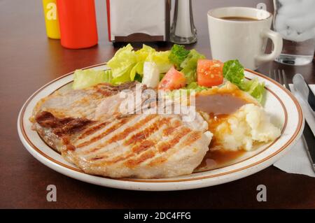 Gegrillte Schweinekoteletts mit Kartoffelpüree und Soße Stockfoto