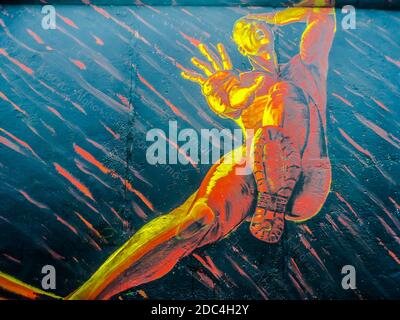 Die East Side Gallery in Berlin. Eine der Wandmalereien, die direkt auf einem langen Überbleibsel der Berliner Mauer gemalt wurden. Stockfoto