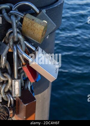 Vorhängeschlösser, die durch eine Kette verbunden sind. Das Konzept der Versklavung. Tag, Nahaufnahme, Details. Stockfoto