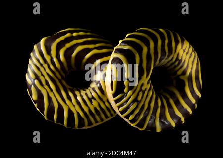 Zwei amerikanische Donuts mit Shekolade auf schwarzem Hintergrund bedeckt Stockfoto