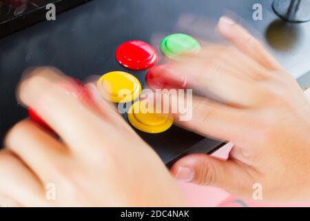 Nahaufnahme verwischen Hände mit Bewegung drücken und halten Joystick von Alte Arcade-Videospiel Stockfoto