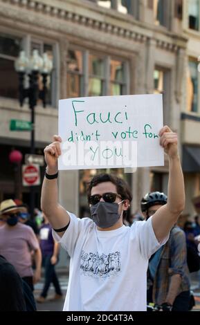 Copley Square, Boston, Massachusetts, USA, 7. November 2020. Eine Reihe von Gemeinschaftsorganisationen versammelten sich, um den Schutz der Demokratie zu fordern und jede Stimme bei den Wahlen 2020 zu zählen. Das Foto zeigt einen Mann, der auf der Boylston Street läuft, mit einem Schild, das auf Dr. Faico verweist. Stockfoto