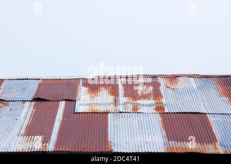 Nahaufnahme einer rostigen Wellblech-Struktur aus Wellblech Altes Dach auf Gebäude isoliert am weißen Himmel Stockfoto