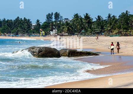 Surfers gehen an Seven Star Rock an der Arugam Bay an der Ostküste Sri Lankas vorbei. Arugam Bay hat einen der besten Point Breaks im Land. Stockfoto