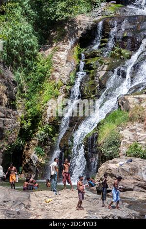 Badegäste kühlen sich am Fuße des Ella-Wasserfalls in der Nähe von Tissamaharama in Sri Lanka ab. Stockfoto