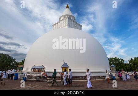 Besucher von Kataragama in Sri Lanka wandern um die Basis von Kiri Vihara, einer Dagoba, die aus dem 1. Jahrhundert v. Chr. stammt. Stockfoto