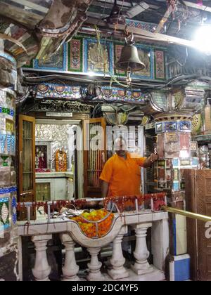 Indien, Rajasthan, Osian, in der Nähe von Jodhpur. Sachiya Mata Jain Tempel, Tempelhelfer neben Opfergaben. Stockfoto