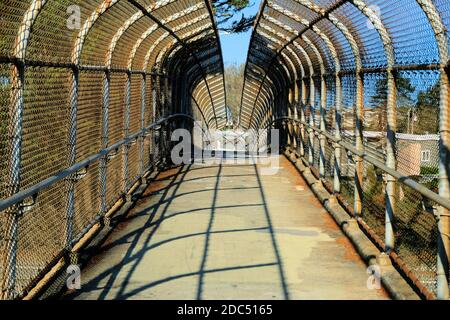 Tunnelansicht einer Fußgängerbrücke, die es Fußgängern ermöglicht, die Autobahn 280 in San Francisco, Kalifornien, USA, zu überqueren; offener Kettenzaun. Stockfoto