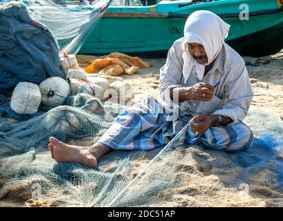 Am frühen Morgen repariert ein Fischer seine Netze am Strand von Arugam Bay in Sri Lanka. Stockfoto