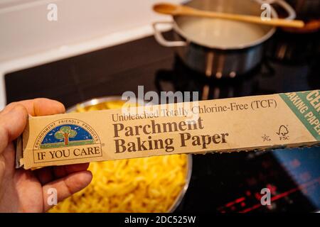 Paris, Frankreich - Nov 11, 2020: Pov männliche Hand hält vor Küchenhintergrund neu Pergament Backpapier hergestellt von If you are totally chlorid-free Stockfoto