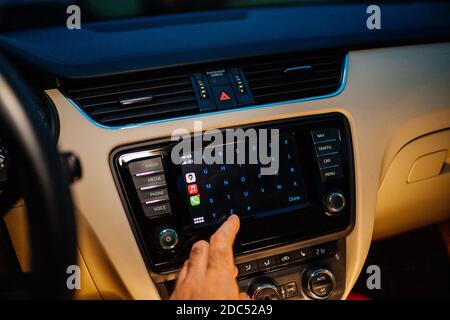 Paris, Frankreich - Nov 11, 2020: Hand drücken Brief auf Infotainment Auto Computer-System mit Apple Computers CarPlay Kontaktliste Menü Stockfoto