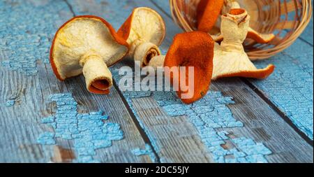 Orange Pilze auf einem hölzernen Hintergrund. Selektiver, verschwommener Fokus. Mandarinenpilze, kreatives Produkt. Stockfoto