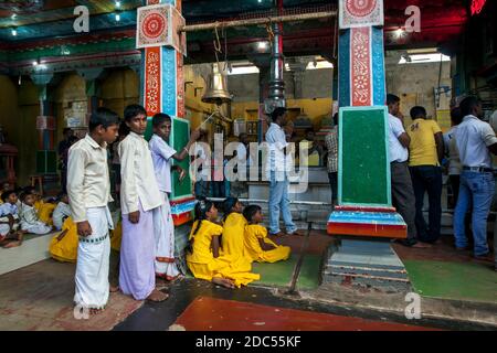 Hinduistische Jungen läuten eine zeremonielle Glocke während Puja (Gebete) in Koneswaram Kovil in Trincomalee an der Ostküste von SriLanka. Stockfoto