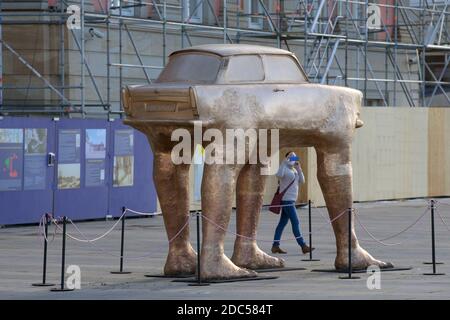 Potsdam, Deutschland. November 2020. Eine junge Frau filmt die Trabi-Skulptur auf dem Steubenplatz neben dem Landtag mit ihrem Smartphone. Das Kunstwerk "Quo Vadis" des tschechischen Künstlers David Cerny wurde kürzlich durch eine goldfarbene Kopie ersetzt. Quelle: Soeren Stache/dpa-Zentralbild/ZB/dpa/Alamy Live News Stockfoto